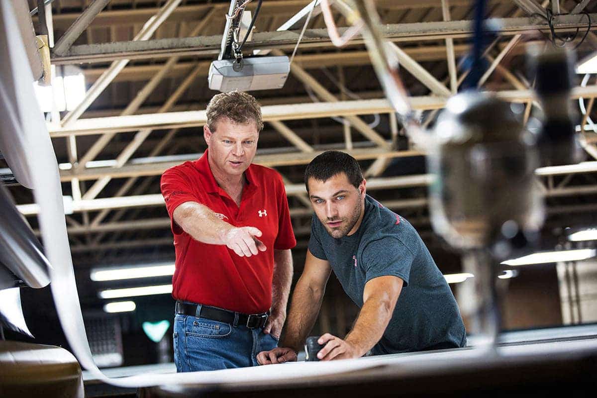 During a corporate photography session in Chicago, two men in a factory are studying a piece of paper.