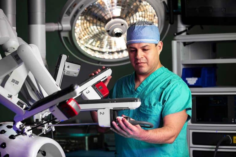 A surgeon in an operating room with a robotic arm during a corporate photography session in Chicago.