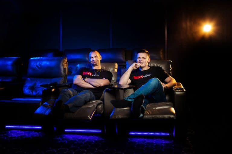 Two men seated in lounge chairs in a theater during a corporate photography session in Chicago.