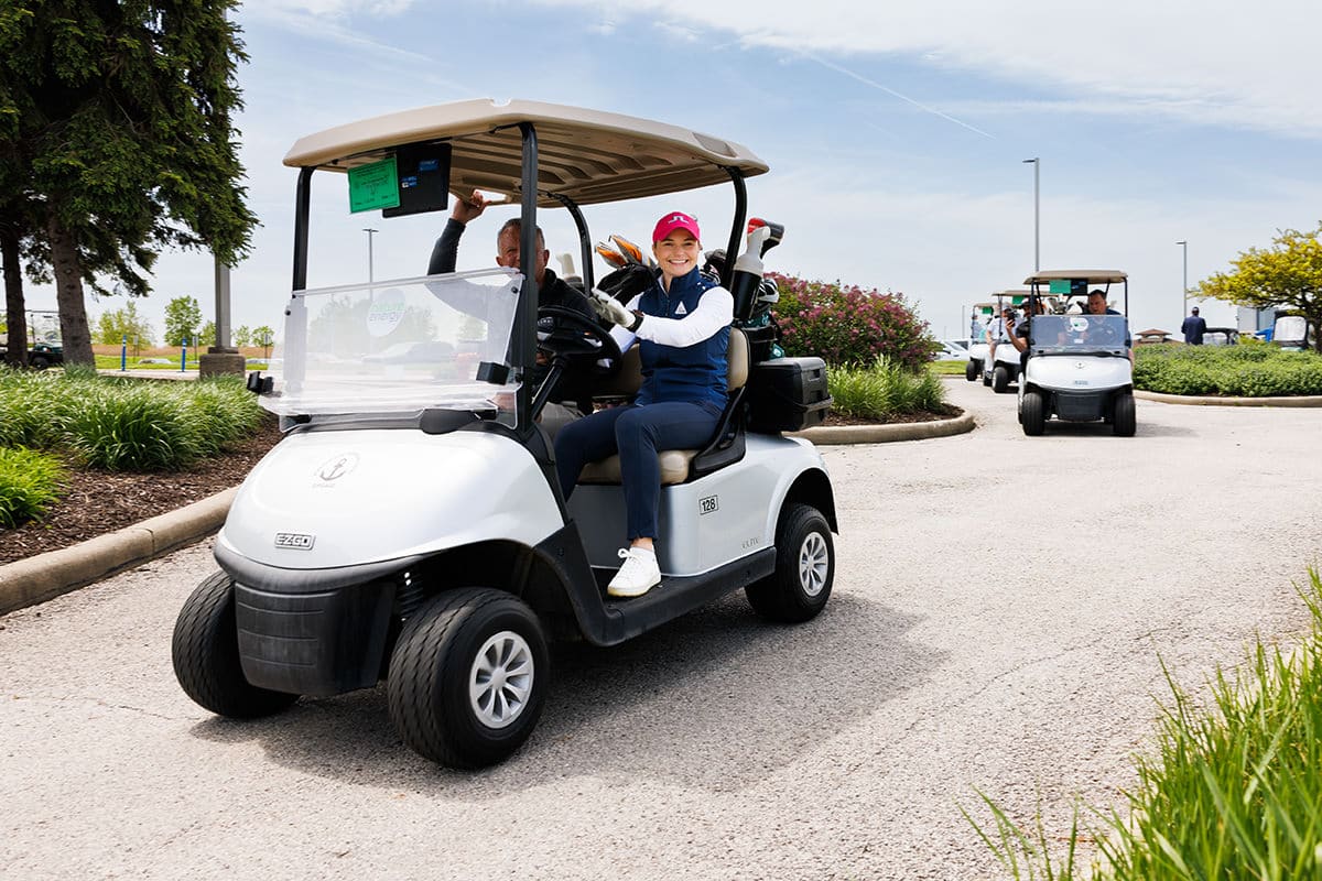 Attendees riding in a golf cart during an outdoor corporate event, photographed by Chicago corporate event photographer Tori Soper.