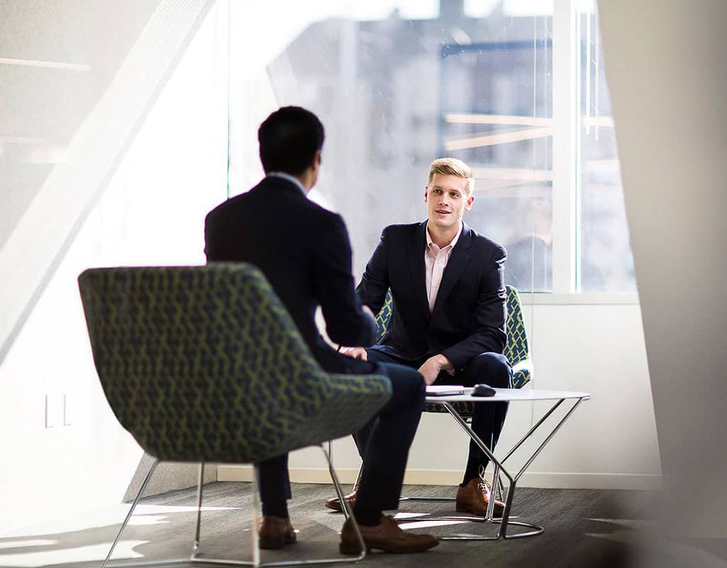 Executives in a strategy meeting in a bright modern office lounge, Chicago Business Photography for corporate branding.