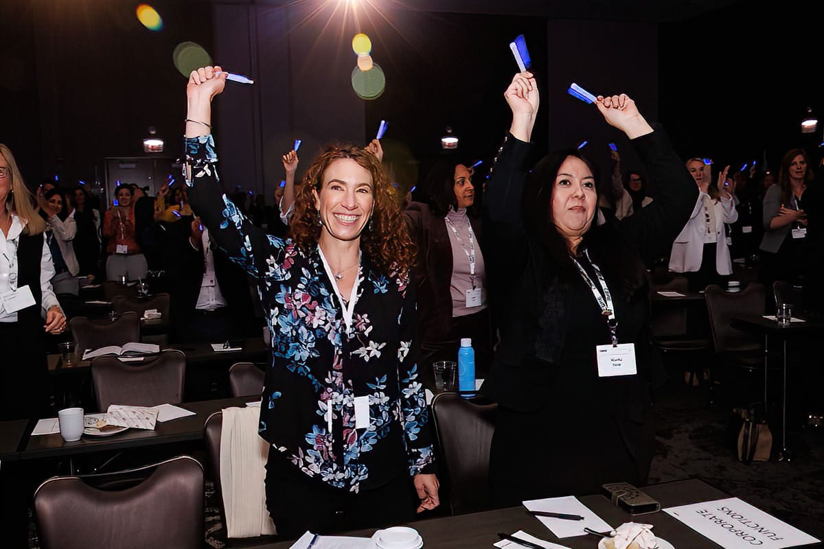 Event photography coverage of two women holding glow sticks in the air at a corporate event in Chicago.