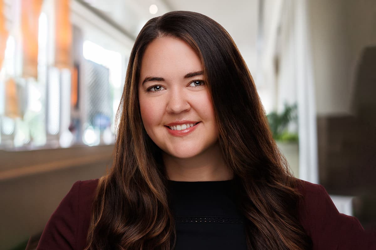 Chicago corporate headshots – professional environmental portrait of a smiling woman in an indoor office setting.