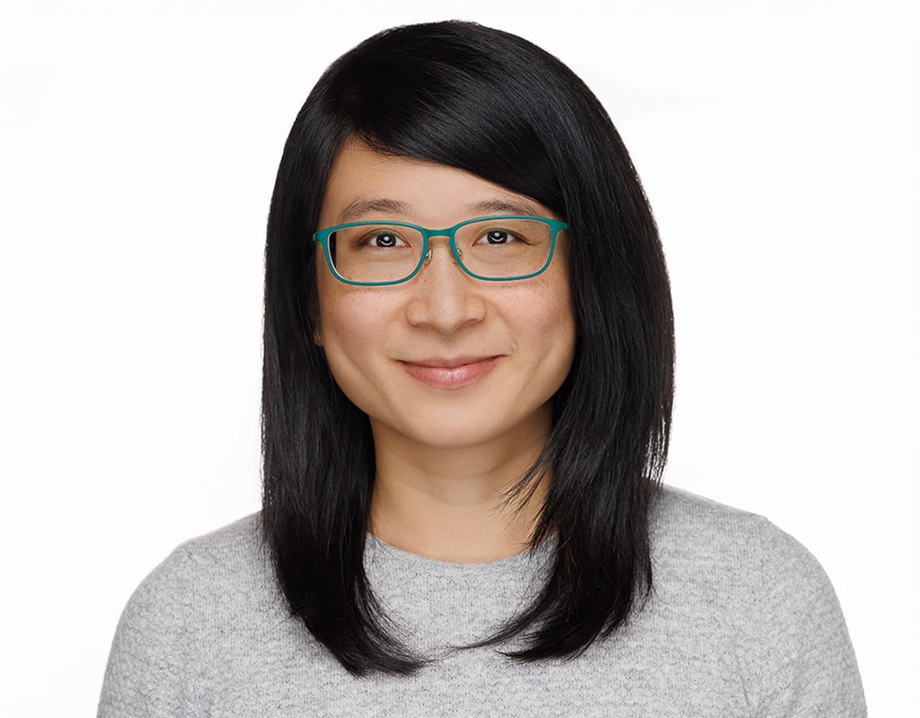 Headshot of a woman with glasses and a gray sweater, Chicago corporate headshots.