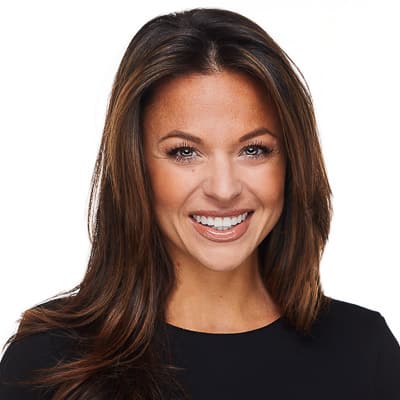 Professional woman with long brown hair smiling at the camera for a corporate headshot.