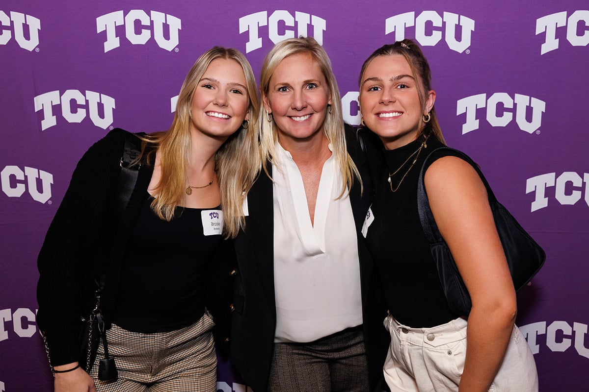 Attendees posing for a group photo at a branded step-and-repeat backdrop, photographed by Chicago corporate event photographer Tori Soper.