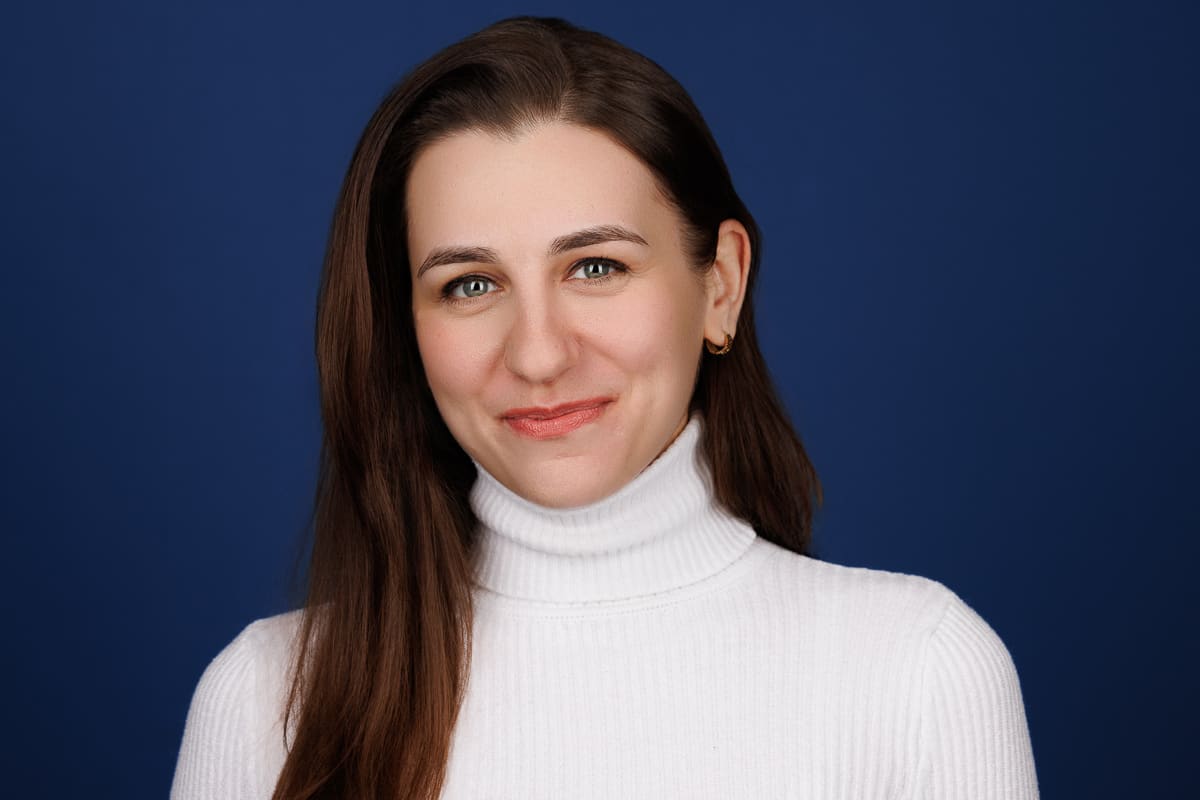Professional executive woman in a white turtleneck, smiling confidently, Chicago corporate headshot by Tori Soper Photography.